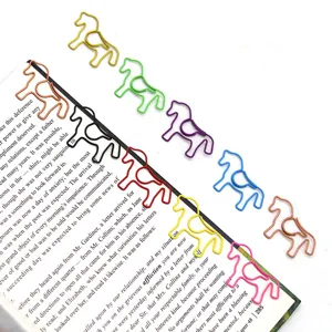 Close-up detail of colorful horse shaped paper clips clipped onto an open book page
