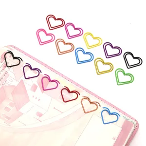 Primer plano de clips de papel metálicos coloridos en forma de corazón para documentos.