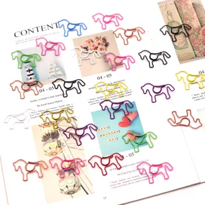 Detail of creative horse-shaped paper clips in various vibrant colors scattered on a book