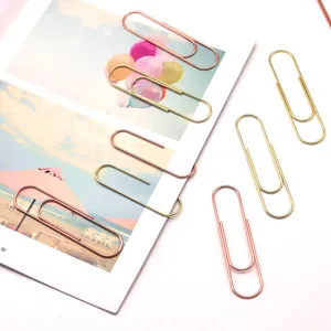 Close-up detail of large gold and rose gold metal paper clips for office document organization.