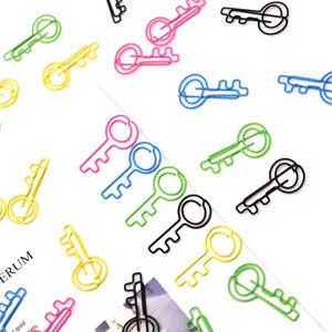 Detailopname van kleurrijke sleutelvormige metalen paperclips voor kantoororganisatie.
