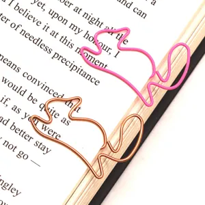 Close-up detail of cute squirrel shaped metal paper clips and bookmarks in pink and bronze.