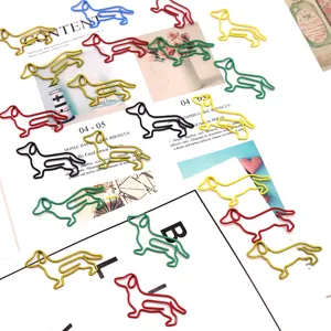 Detailed view of cute metal dachshund shaped paper clips, colorful coated wire stationery for office.