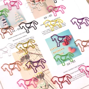 Creative horse-shaped metal paper clips in various colors displayed on a magazine page