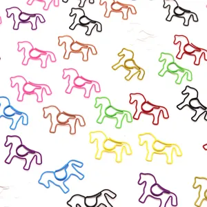 Close-up detail of various colorful horse-shaped metal paper clips on white background