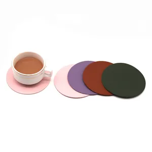 Vista detallada del juego de posavasos de cuero colorido con taza de café blanca.