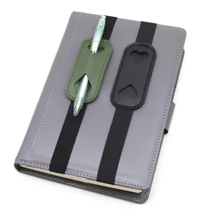 Close-up detail of PU leather pen holder elastic band for notebook, grey notebook with straps.
