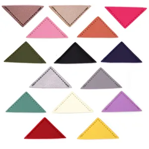 Colorful PU leather triangle corner clips and bookmarks, office stationery details close up view.