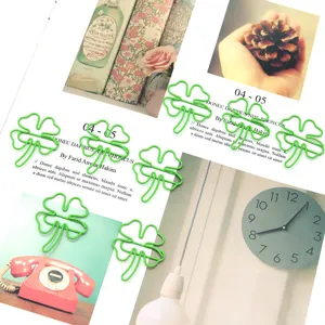 Detailed view of creative green four-leaf clover metal paper clips and cute stationery bookmarks.