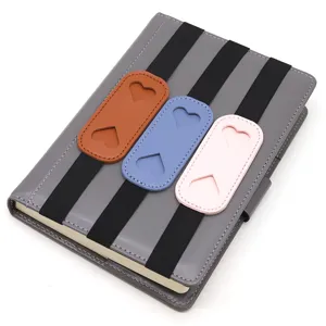 Elastic notebook pen holder band with cute heart leather loops for journal diary organizing.