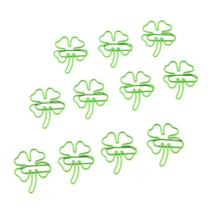 Close-up detail view of cute green four-leaf clover shaped wire paperclips stationery set item
