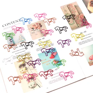 Colorful horse-shaped paper clips scattered on an open magazine page