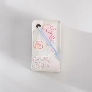 Close-up view of the clear acrylic notebook cover featuring cute pink cartoon illustration and blue strap.