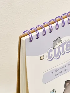 Nahaufnahme vom süßen Katzen Spiral-Skizzenbuch Cover mit lila Drahtbindung und Kraftpapier.