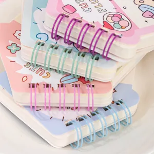 Detailed view of cute pocket coil notebook stack, colorful metal rings, stationery close up.