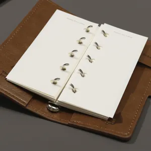 Carnet de notes à feuilles mobiles en cuir marron avec anneaux métalliques pour la planification.