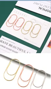 Large metal paper clips, creative oval bookmarks, colorful office stationery supplies.