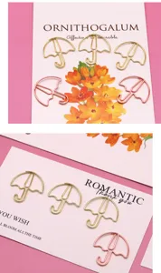 Nahaufnahme kreativer regenschirmförmiger Büroklammern in Gold und Roségold-Finish