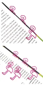 Close-up view of cute pink flamingo metal paper clips holding book pages securely, detailed shot.