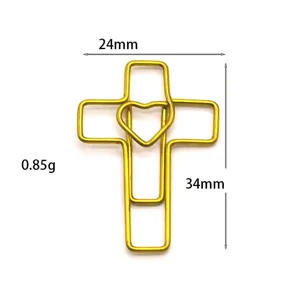 Close-up of a gold cross heart paperclip, metal bookmark and creative office supply.