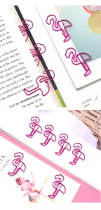 Close-up of cute pink flamingo metal paper clips used as creative bookmarks and student stationery.