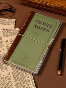 Grünes Reisetagebuch Notizbuch mit transparenter Schutzhülle und Vintage Zeitung Detail