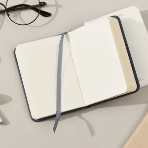 Detalle de las páginas interiores en blanco y la cinta marcapáginas gris en el cuaderno.