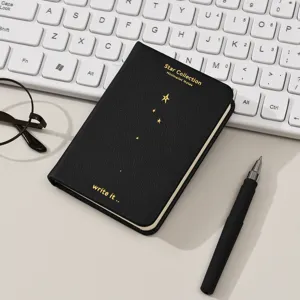 Primer plano detallado de una elegante libreta negra con diseño de constelación.