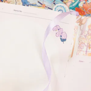 Detailed view of the constellation planner notebook with purple ribbon and flower illustration.
