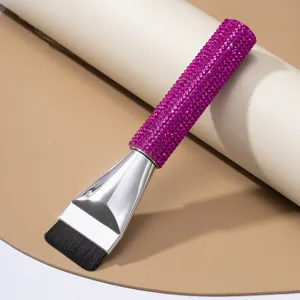 Detail shot of a flat foundation brush with a purple rhinestone encrusted handle