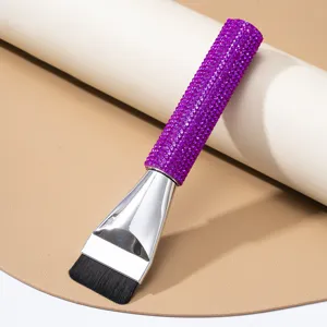 Close-up detail of luxury purple rhinestone handle on professional flat foundation brush