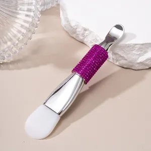 Macro detail of a double-ended silicone facial mask brush with purple rhinestone handle