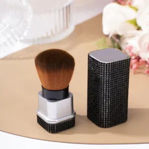 Close-up of a rhinestone-studded nail dust cleaning brush with elegant black gems