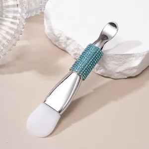 Macro detail of double-headed face mask brush with silicone tip and blue rhinestone handle