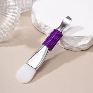Close-up of double-ended silicone mask brush with purple rhinestone handle detail