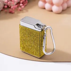 Detail van een draagbare sigarettenkoker met gele strass-steentjes en zilveren sleutelhanger