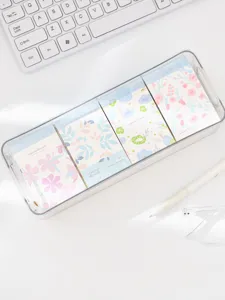 Detail view of Korean style floral memo pads set in a clear storage box on a white desk.