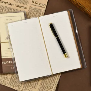 Travel journal notebook with grid pages and metal pen, portable cute diary for daily plans.