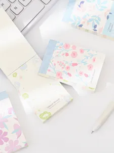 Close-up detail of aesthetic floral sticky notes and memo pads, soft pastel design for journaling.