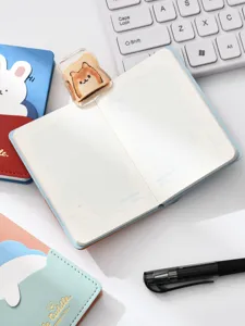 Vista detallada de cuaderno de bolsillo portátil con diseño bonito, páginas cuadriculadas y papelería.