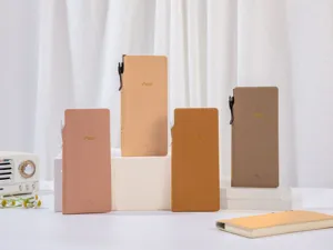 Varietà di quaderni sottili B5 in toni terra esposti con accessori retrò estetici