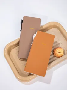 Vista dettagliata di taccuini B5 marroni e arancioni su un vassoio beige