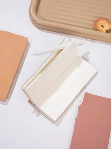 Taccuino B5 minimalista con carta bianco crema e penna abbinata in ambiente da ufficio