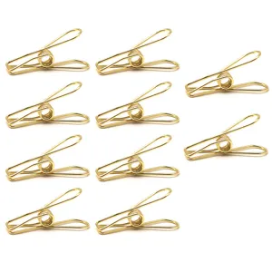 Détail de mini pinces à papier en fil de métal doré, idéal pour classement et bureau.