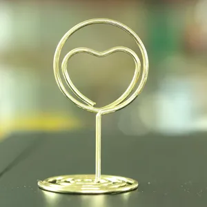 Nahaufnahme eines goldenen Metall-Tischnummernhalters in Herzform mit stabilem Spiralboden