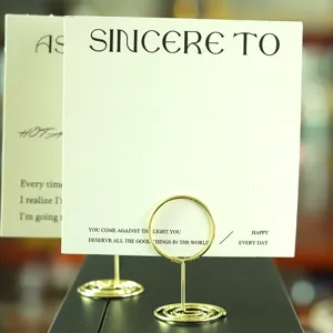 Makro-Detail des goldenen Metall-Kartenhalters mit Spiralbasis und rundem Ringclip-Design