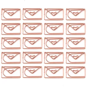 Nahaufnahme von roségoldenen büroklammern in umschlagform, metallische lesezeichen.