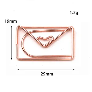 Detailansicht der kreativen metallenen Büroklammer in Roségold mit Umschlagform.