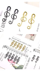 Detailansicht kreativer Noten Büroklammern in Gold und Schwarz, perfekte Metall Buchklammern.