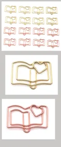 Detailed view of cute book shaped metal paper clips in gold and rose gold colors.